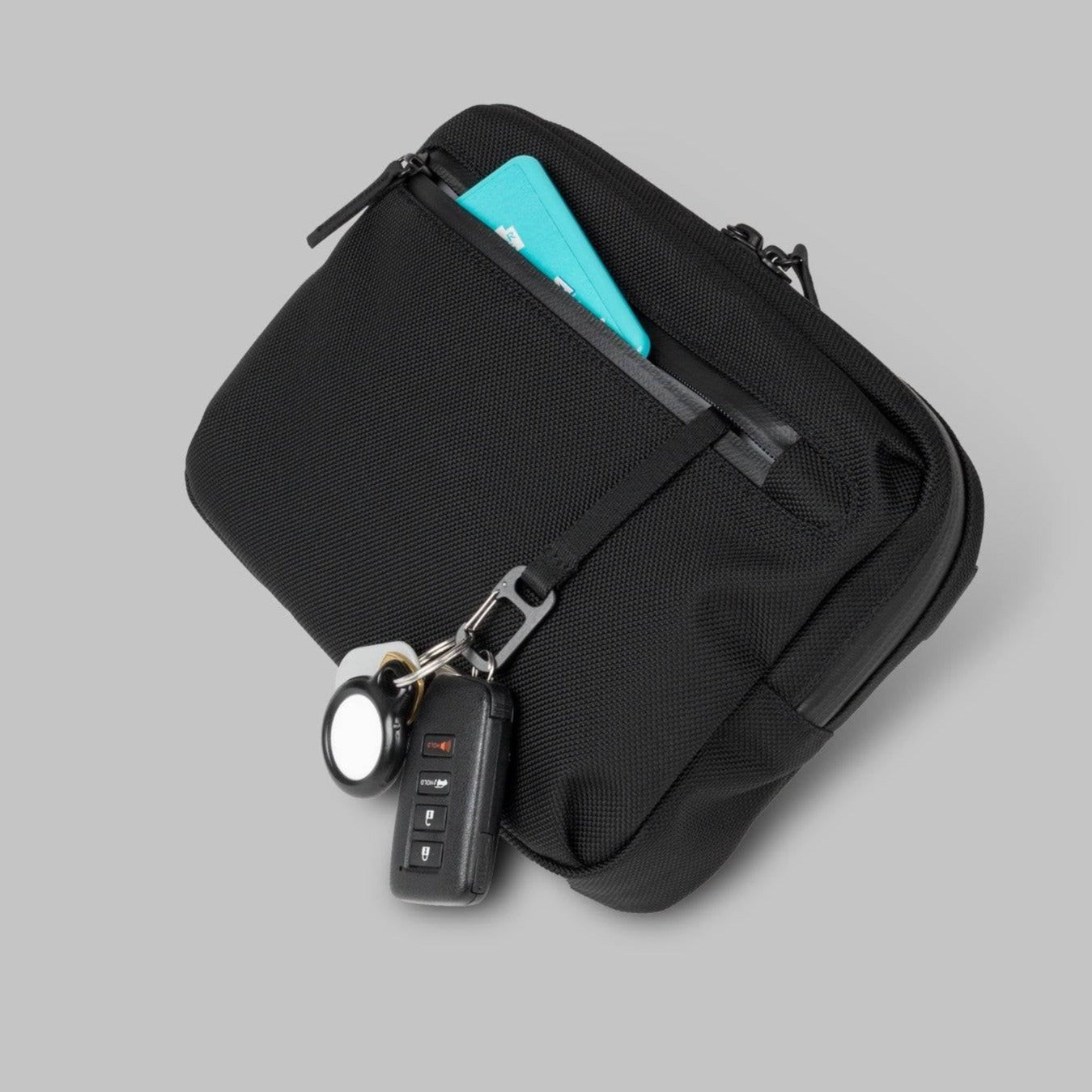  Rework Gear Essentials Case with a key leash and a set of keys hanging out the front pocket.