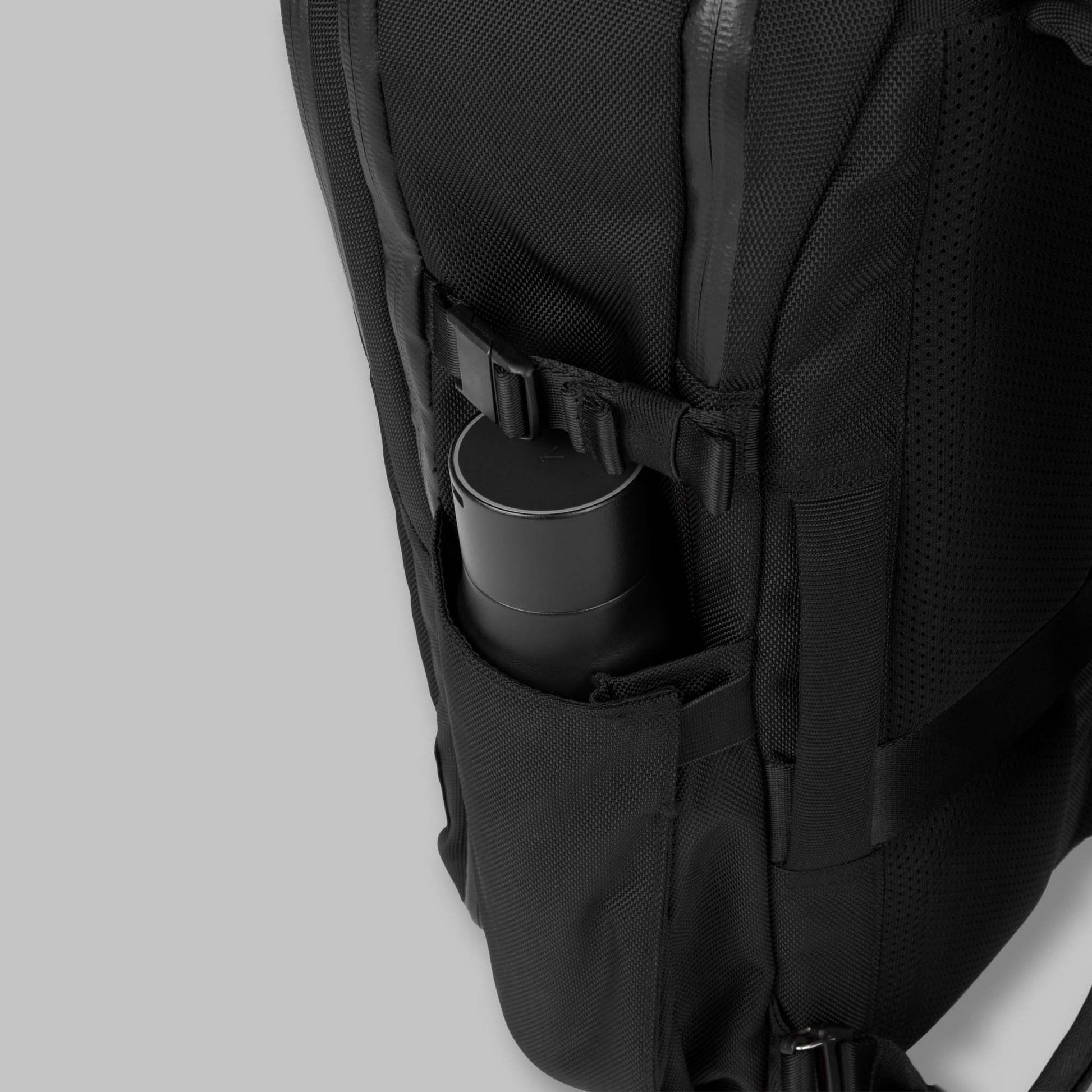 Side pocket of the 22L Reset Pack by Rework Gear packed with a water bottle.